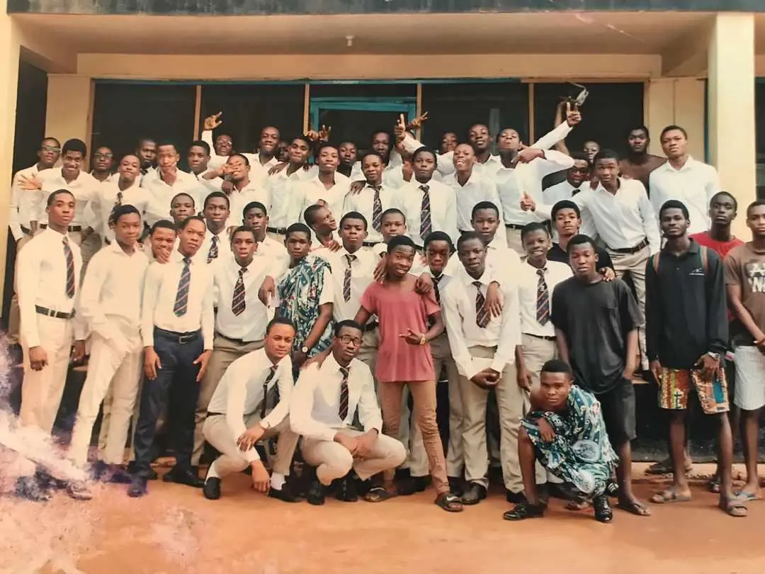 The year group in white shirts and ties on the school compound